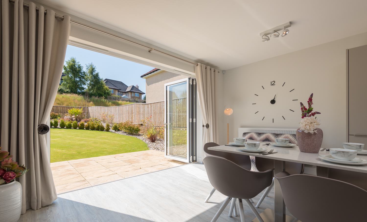 Open bifold doors from a modern dining room