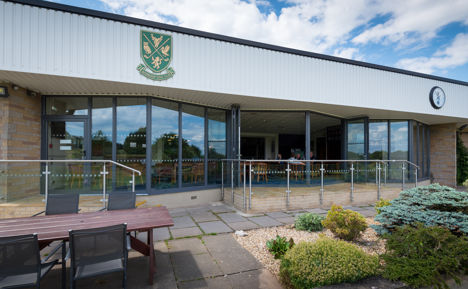 Open bifold doors of a golf club bar from an outdoor view