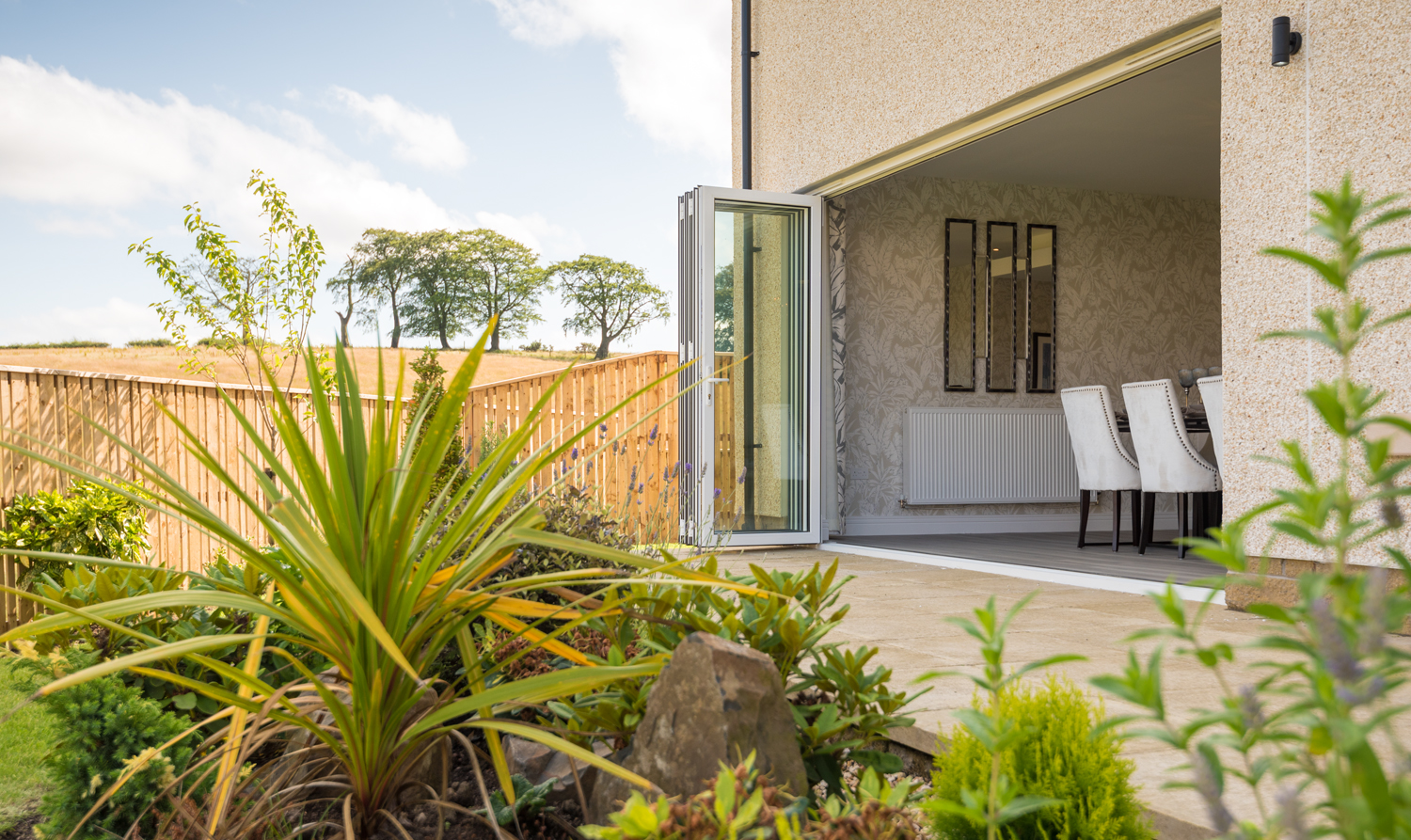 Open Bifold doors leading from a modern dining room