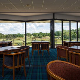 View from inside a golf club looking out through bifold doors onto the course