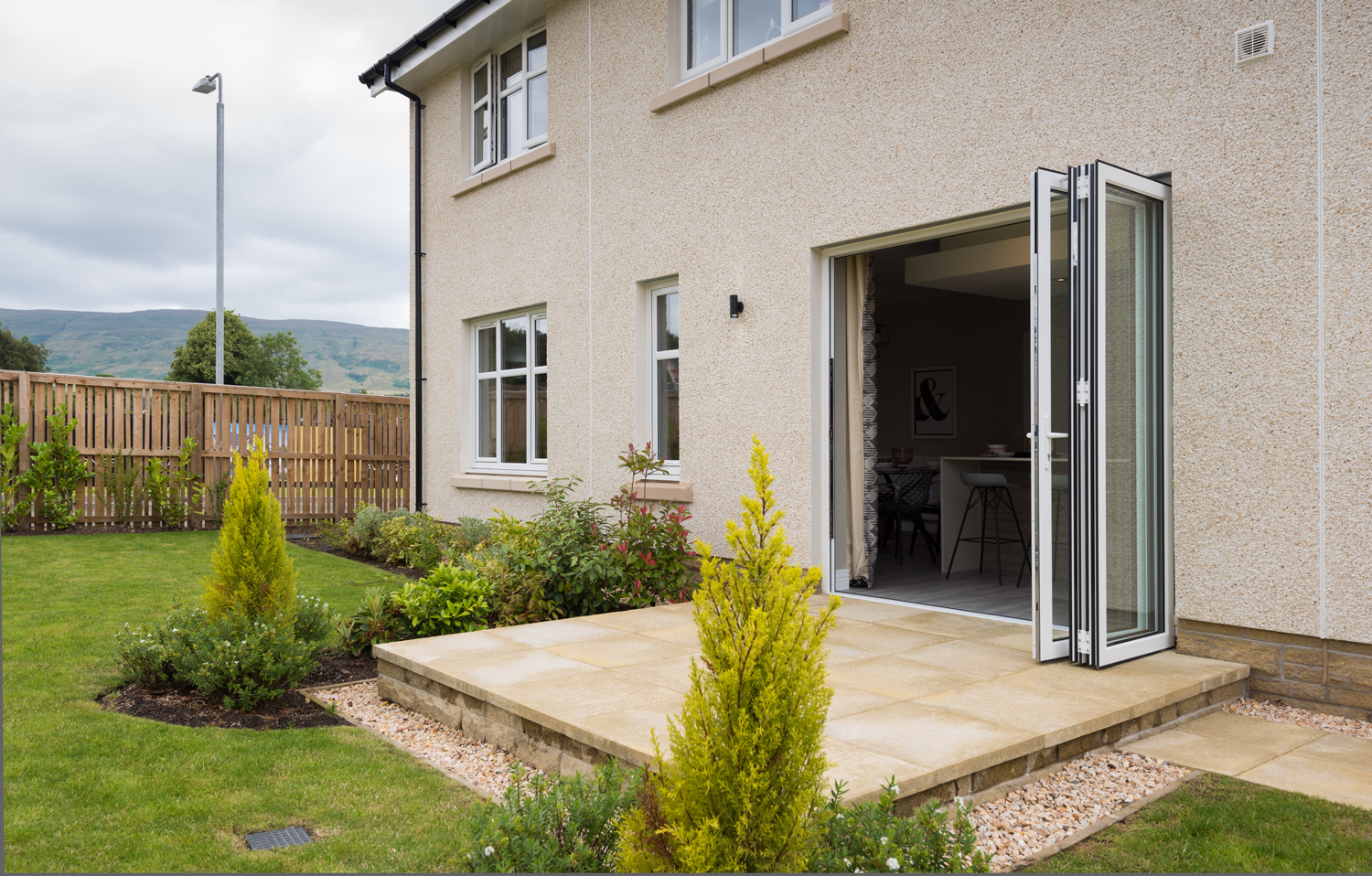 Open bifolds leading into a kitchen from the view of the garden