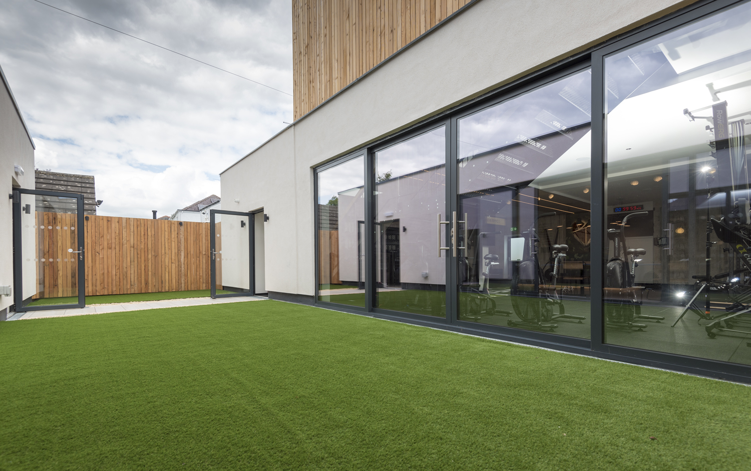 Outside of the gym looking onto bright green grass with 2 open bifold doors in the background