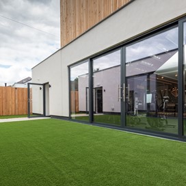 Outside of the gym looking onto bright green grass with 2 open bifold doors in the background
