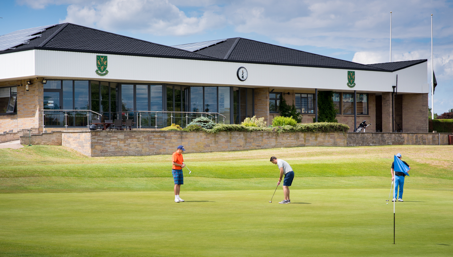 Wide view of a golf club with golfers in the foreground