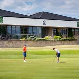 Wide view of a golf club with golfers in the foreground
