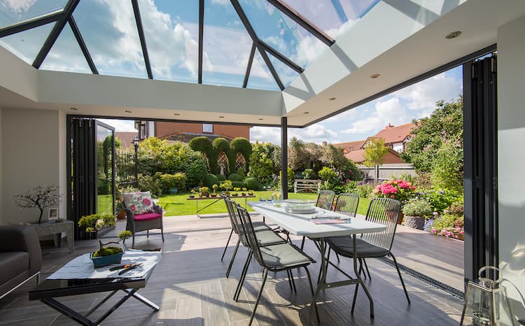 Origin corner bifold doors in an orangery looking over the garden