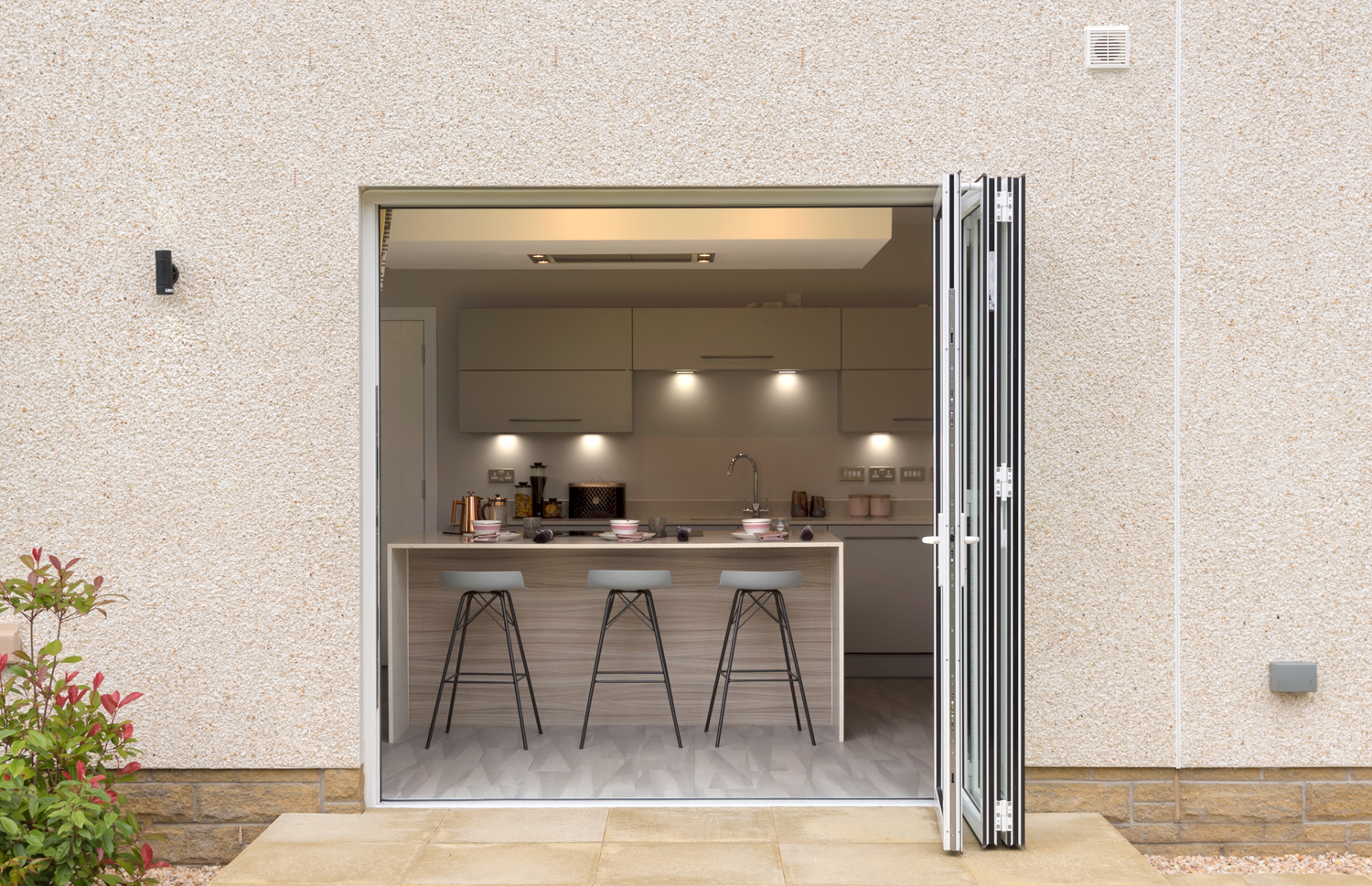 Open white Origin bifold doors looking into a modern kitchen