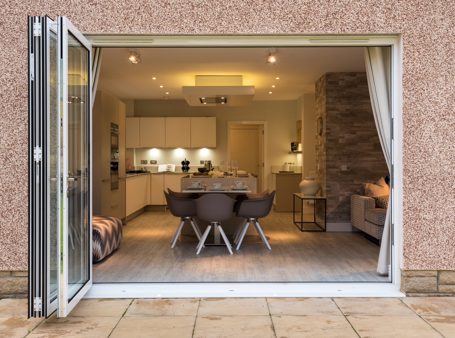 View into a modern decorated dining room through open bifold doors