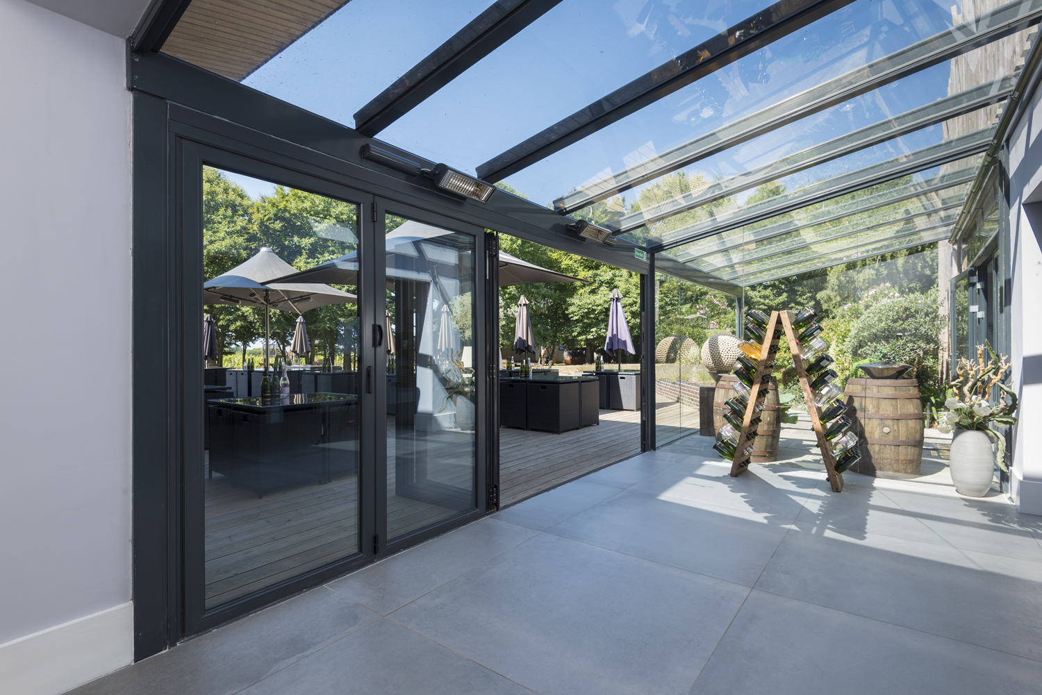 Inside of a bar viewing the bar garden through half open bifold doors