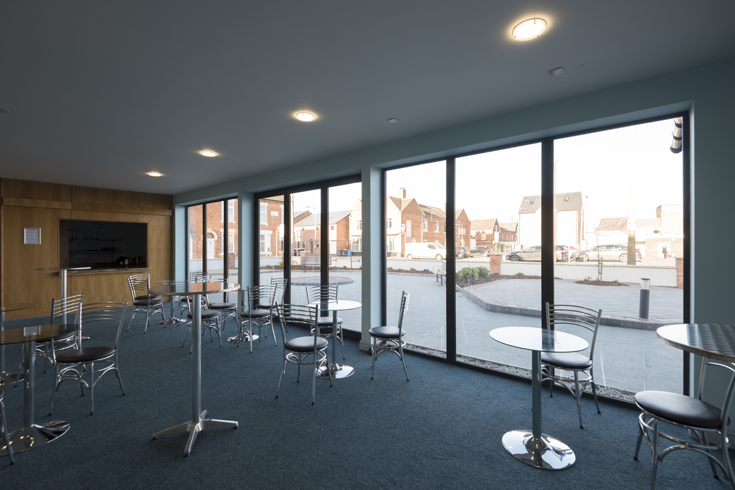 Indoor view of tables and chairs leading onto the road