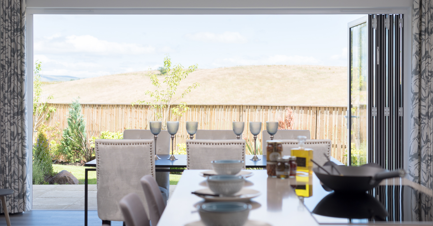 Open bifolds from inside of a modern dining room leading into the garden