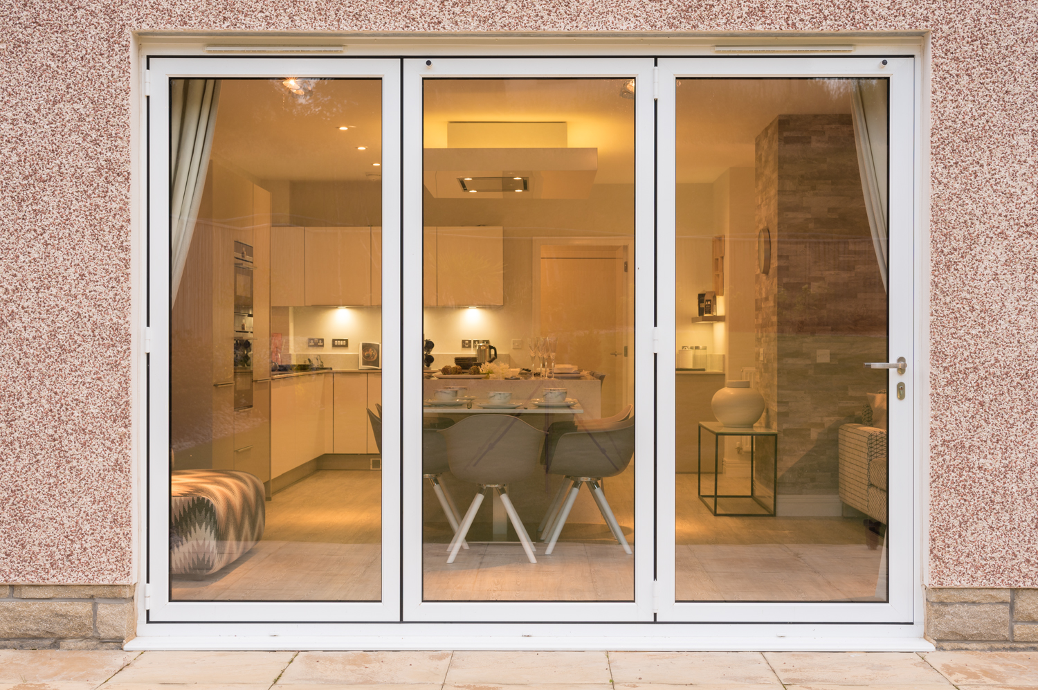 Closed bifold doors viewing into a dining room and kitchen